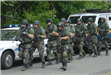 A team of police officers in camo holding firearms.