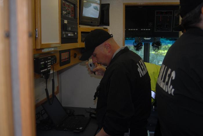 Police officers working in a command truck.