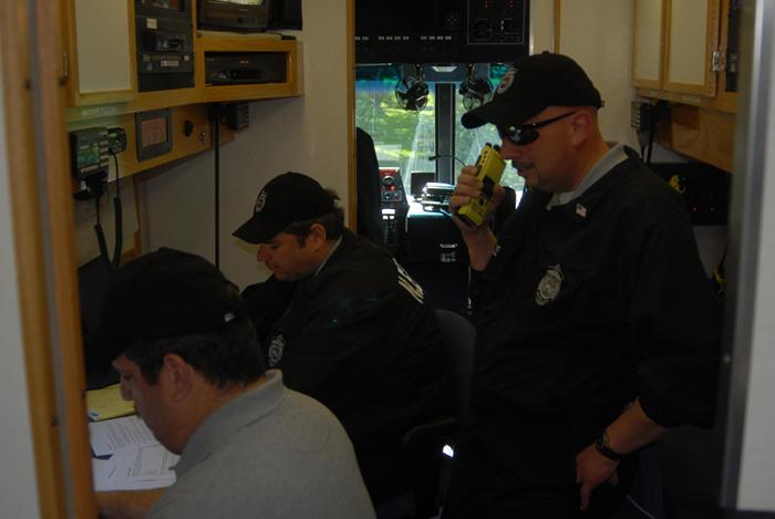 Police officers working in a command vehicle.