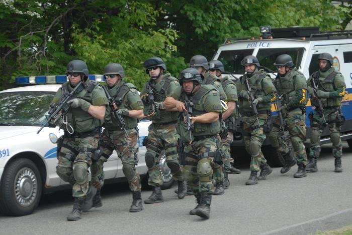 A team of police officers in camo holding firearms.