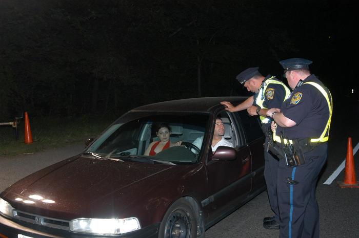 Police officers talking to the passengers of a car.